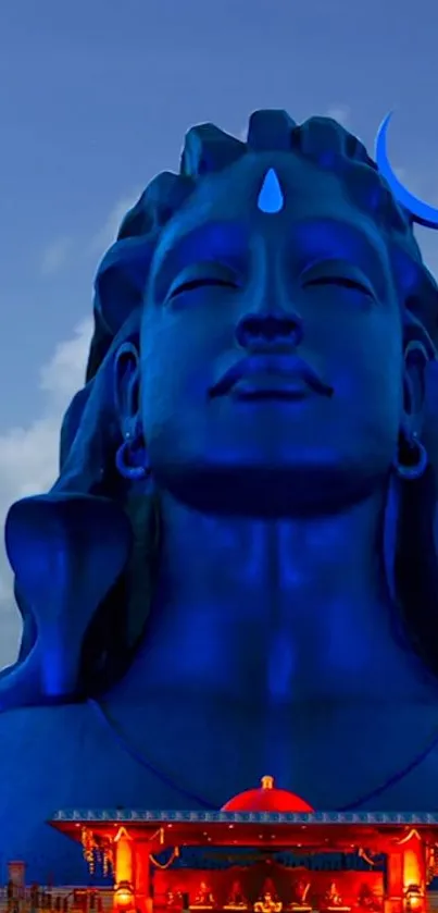 Majestic blue Shiva statue with serene expression and vibrant sky.