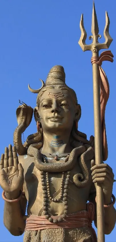 A majestic Shiva statue against a clear blue sky.