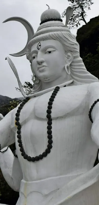 Majestic white Shiva sculpture amid nature, perfect for mobile wallpaper.