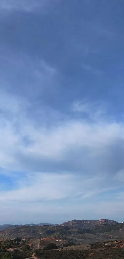 Expansive sky over distant mountain view, perfect for a calming mobile wallpaper.