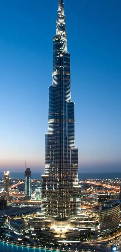 Twilight view of a majestic skyscraper reflecting city lights against a darkening sky.