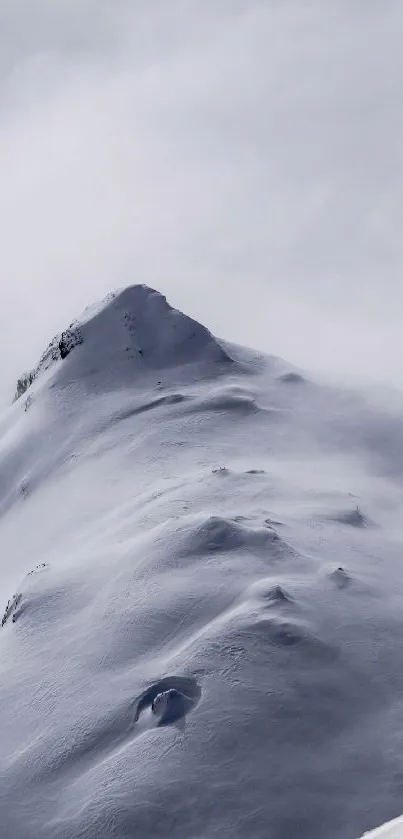 Snowy mountain peak shrouded in mist.