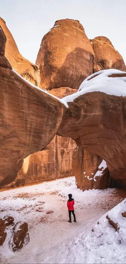 Snow-covered arch in a desert landscape.