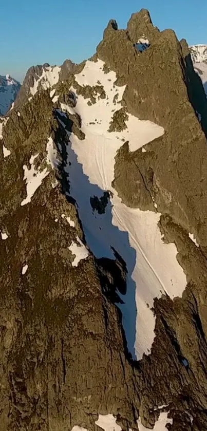 Snowy mountain peaks under blue sky, offering a breathtaking natural view.