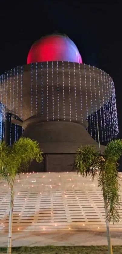 Majestic night structure with lights and palm trees.