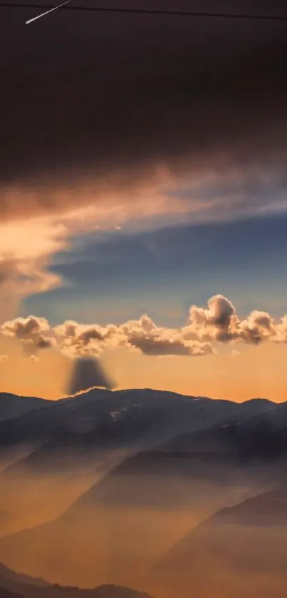 Sunset view of mountains with clouds casting a golden hue over the landscape.