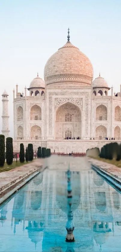 Taj Mahal reflected in serene water under a blue sky.