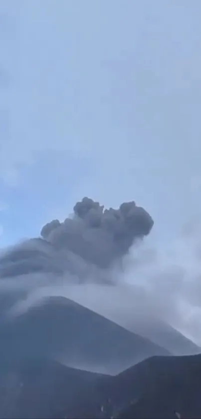 Stunning view of a volcano erupting with smoke against a blue sky.