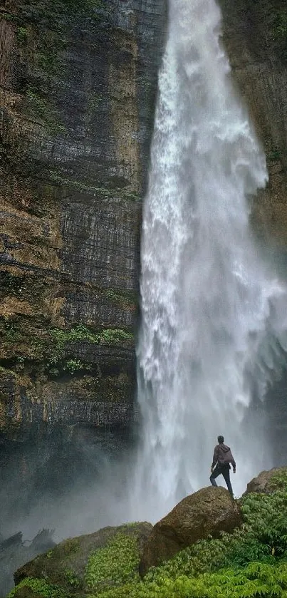 Stunning waterfall with adventurer on rocky landscape.