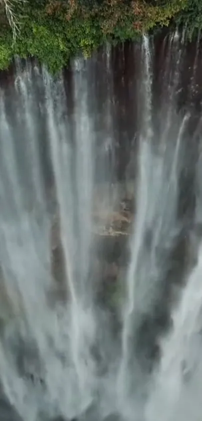 Aerial view of a majestic waterfall with cascading streams and lush greenery.