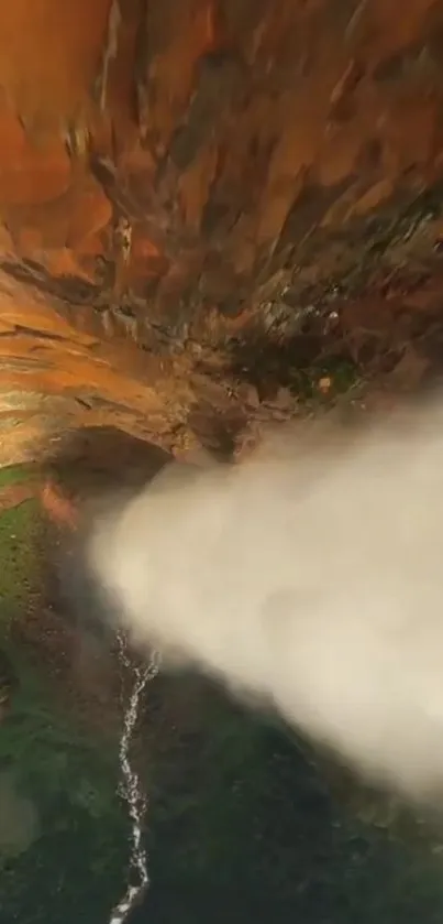 Aerial view of a waterfall cascading over colorful, rocky cliffs.