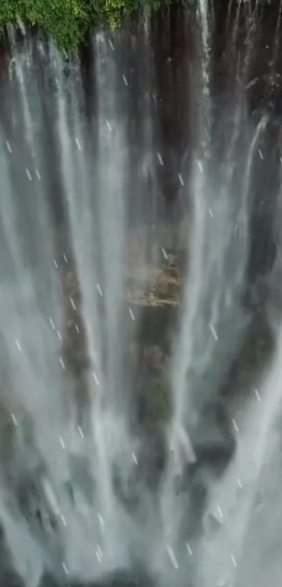 Aerial view of a dramatic waterfall surrounded by lush greenery.