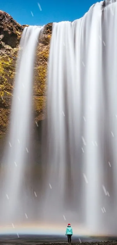 Majestic waterfall with a rainbow and vivid blue sky background.