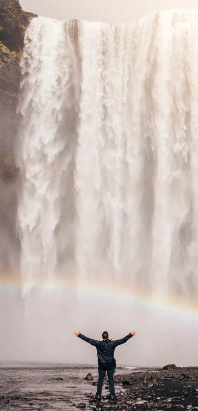 Majestic waterfall with rainbow arc in a serene natural setting.