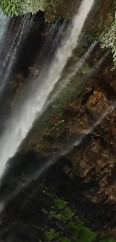 Waterfall cascading over rocky cliffs with lush green surroundings.