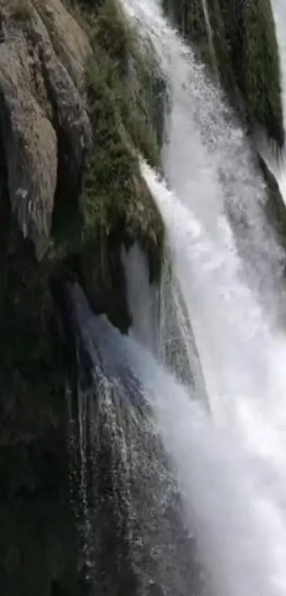 Majestic waterfall with lush greenery and misty water.