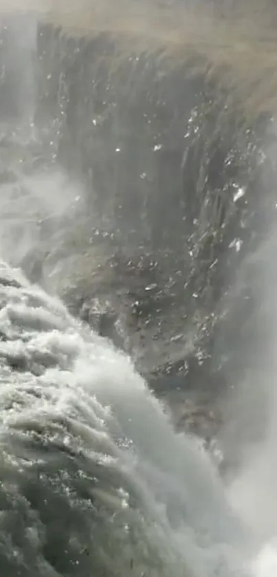 Majestic waterfall against rocky cliffs in serene setting.