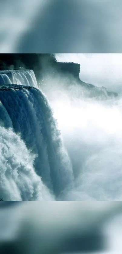 A majestic waterfall with mist in blue hues cascading down rocks. Perfect as a wallpaper.