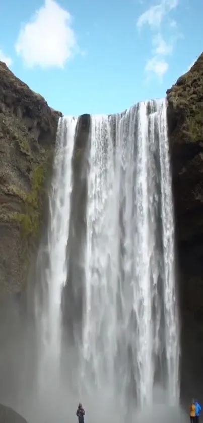 Majestic waterfall cascading into a serene pool with a clear blue sky.