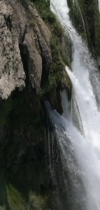 Majestic waterfall cascading down rocky cliffs in nature wallpaper.