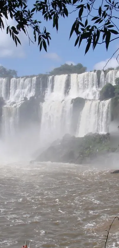 Majestic waterfall cascading over rocks with lush greenery.