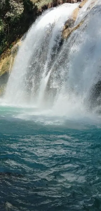 Majestic waterfall cascading into turquoise water, surrounded by lush greenery.