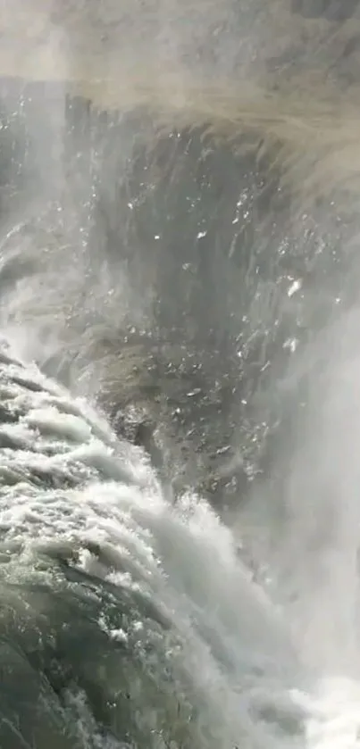 Majestic waterfall cascading down rocky cliffs in serene natural setting.