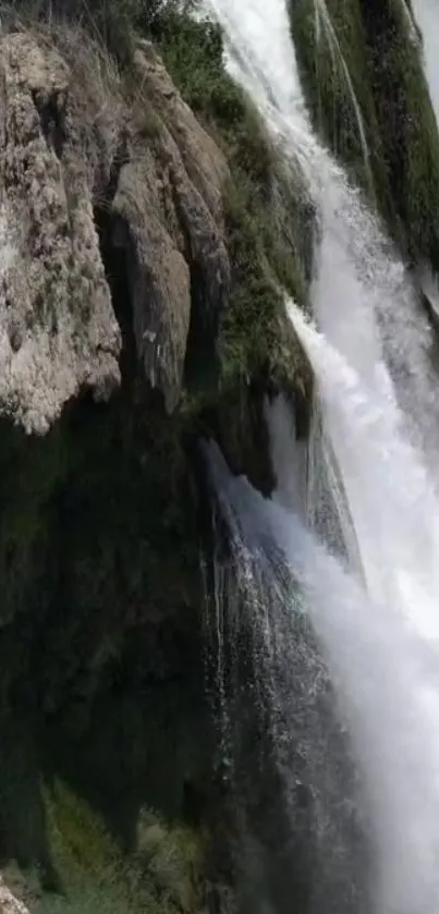 Majestic waterfall with rocky cliffs and vibrant greenery.