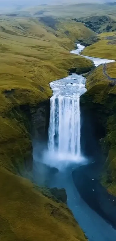 Majestic waterfall cascading through green valley landscape.