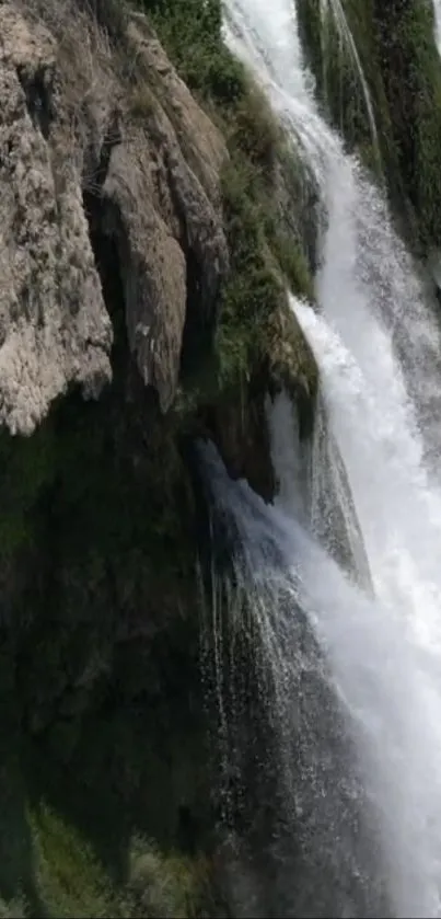 Majestic waterfall cascading over rocks in a serene natural setting.