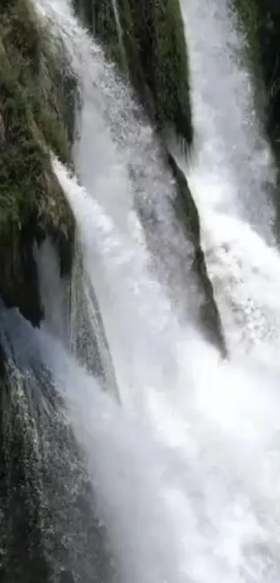 Beautiful cascading waterfall over rocks in a lush green forest.