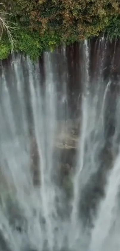 Stunning vertical waterfall with lush greenery in the background.