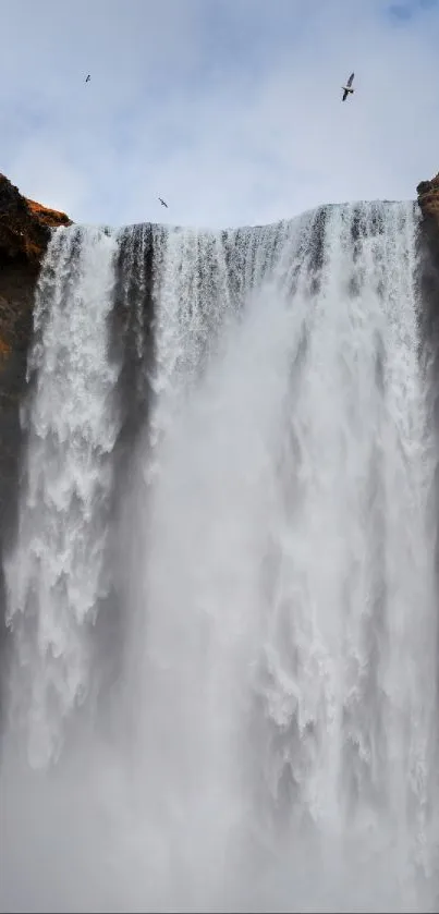 Majestic waterfall cascades over rocky cliffs, creating a serene and powerful scene.