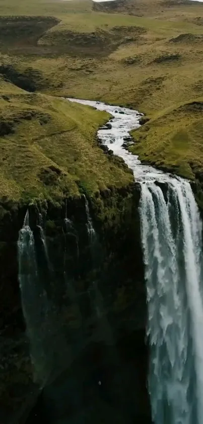 Majestic waterfall amid lush greenery landscape wallpaper.