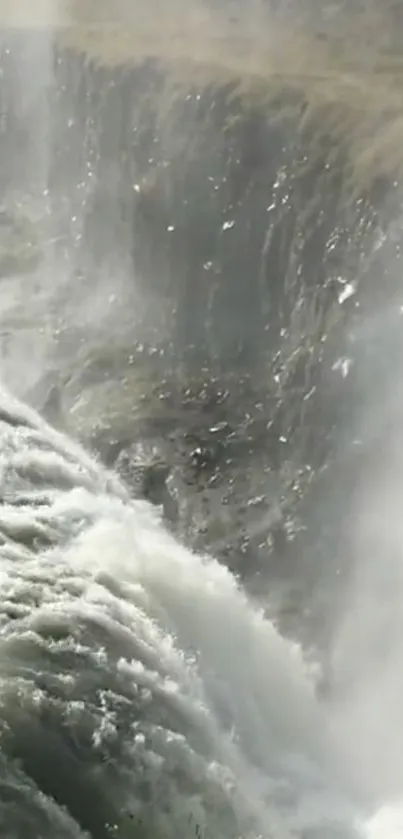 Stunning waterfall with misty spray on a rocky cliff, creating a serene scene.