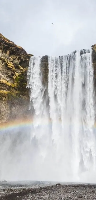 Majestic waterfall with a rainbow in scenic nature view.