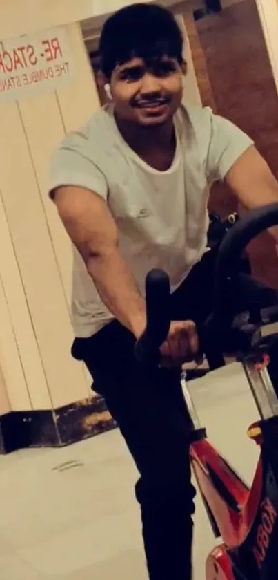 Man cycling indoors at a gym setting.