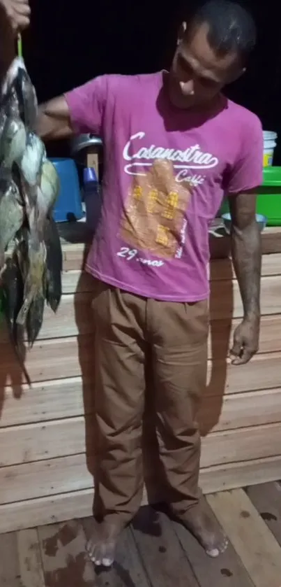 Man holding a line of freshly caught fish indoors.