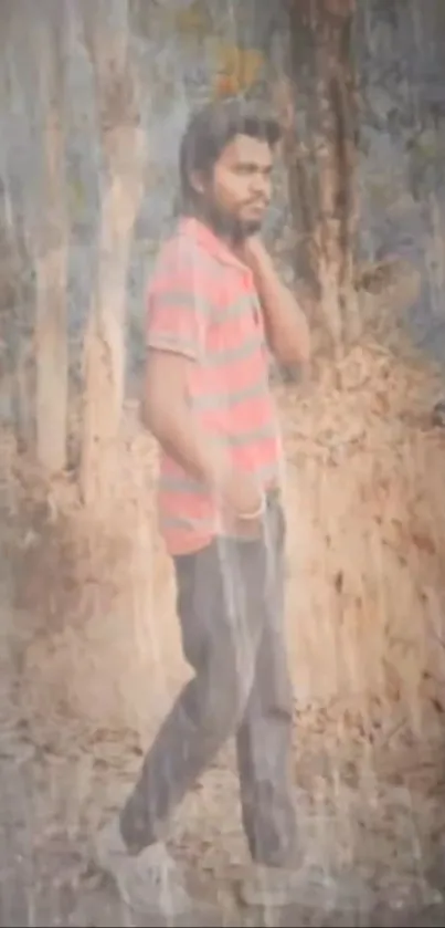 Man in red striped shirt standing in a rainy forest setting.