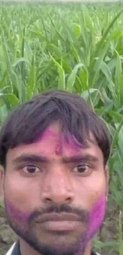 Man with colorful face in a green cornfield.