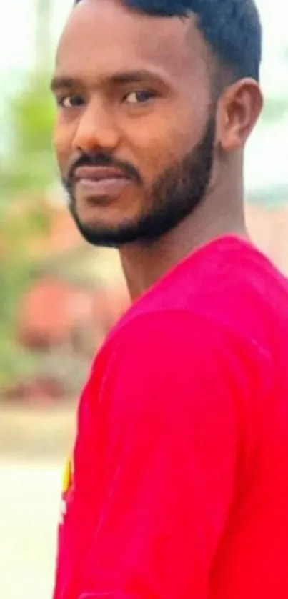 Man wearing a bright red shirt outdoors.