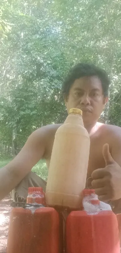 Man giving thumbs up outdoors with bottles.