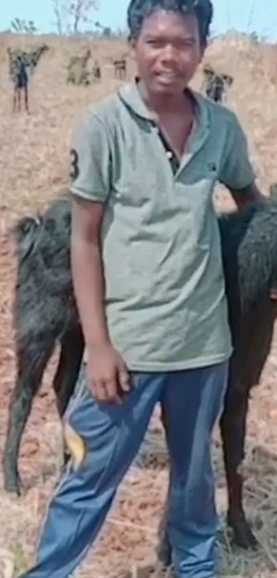 Man standing with a calf in a rural field setting.