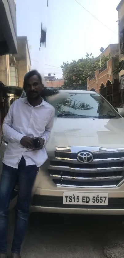 Man leaning on a white SUV parked in an urban street setting.