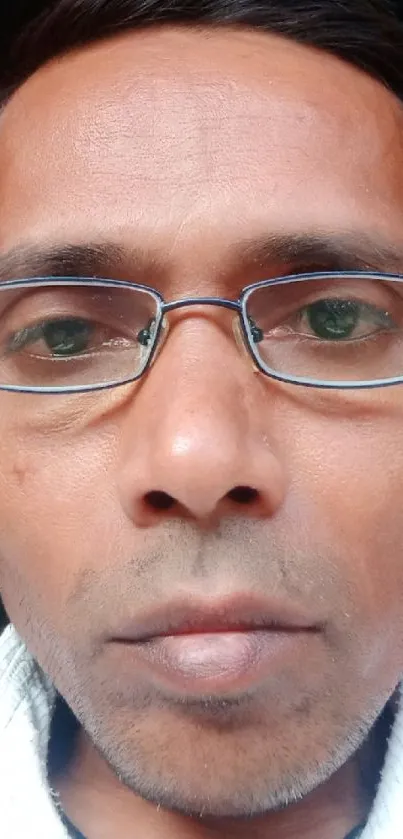 Closeup portrait of a man wearing glasses with a neutral expression.