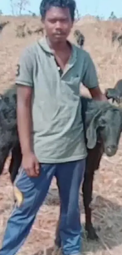 Man standing with goats in an open field, showcasing rural nature.