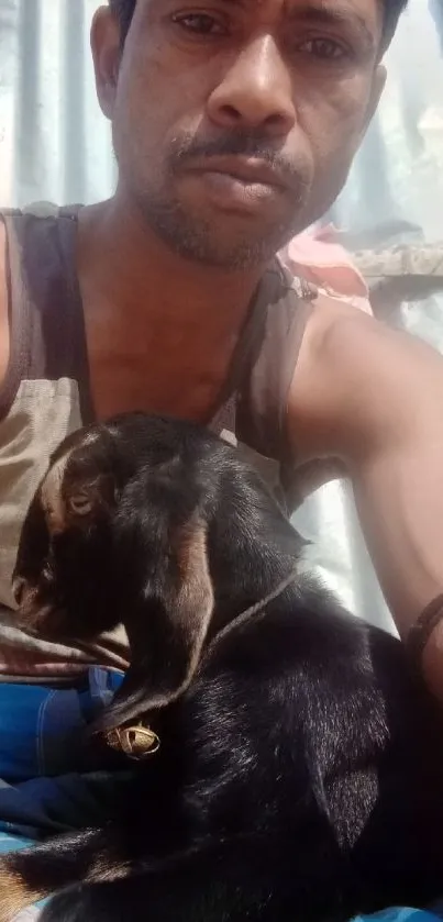 Man cuddling a goat in warm daylight.