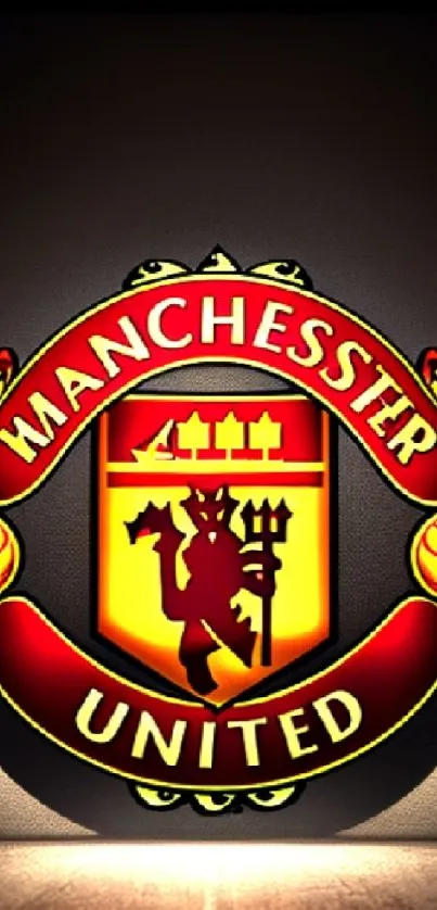 Manchester United red and yellow logo on mobile wallpaper.