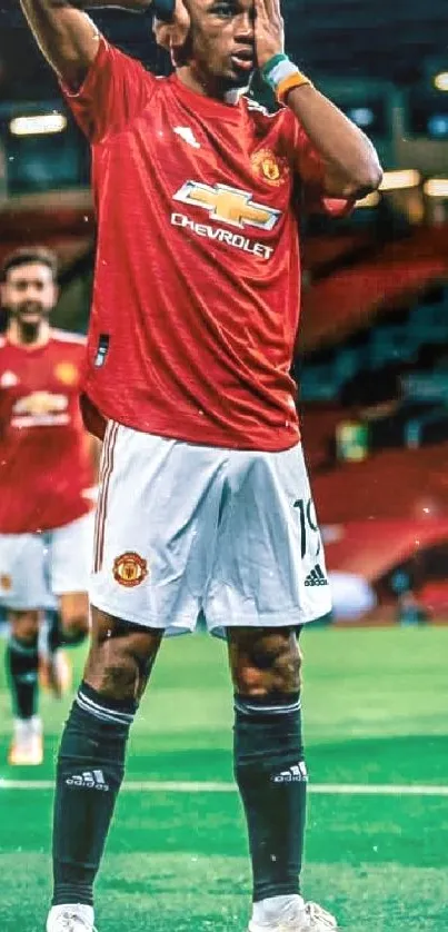 Manchester United player on field in red jersey, dynamic football scene.