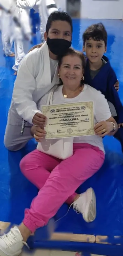 Martial arts family celebration on blue mat.